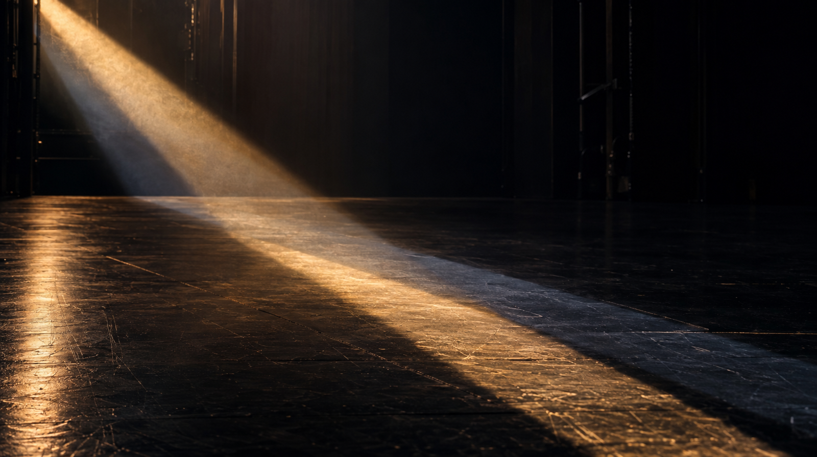 Two overlapping trails of light crossing the same stage floor, one sharp and gold, one fainter and ghostly